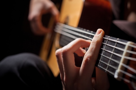 Fingers form a chord on a guitar.