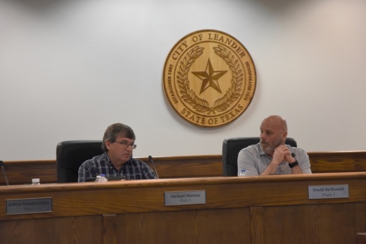 Two Leander City Council Members sit on the dais.
