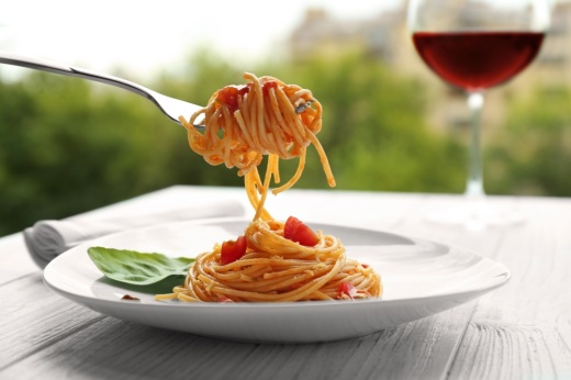 Fork with tasty pasta on blurred background