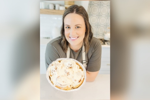 A woman holding a plate of baked goods.