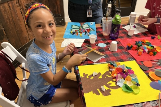 a girl smiles while working on an art project