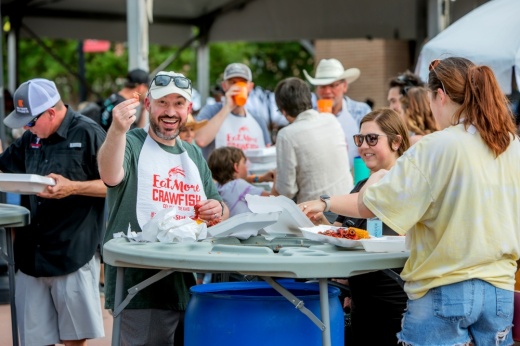 a man holds up a crawfish tail