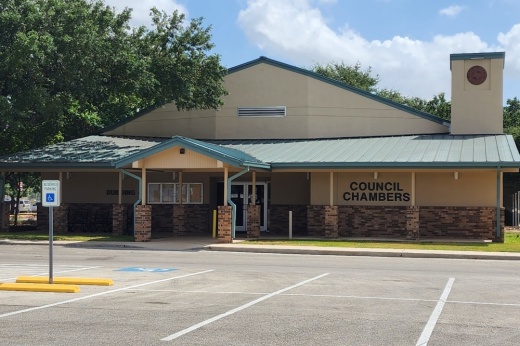 A photo of the outside of city council chambers is shown in Schertz, Texas.