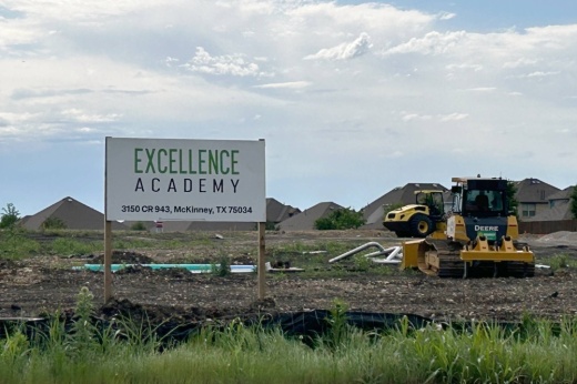 Construction site with wood MDO sign with Excellence Academy verbiage.