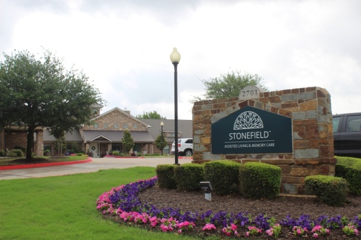 Image of the Stonefield Assisted Living and Memory Care sign with the facility pictured in the background