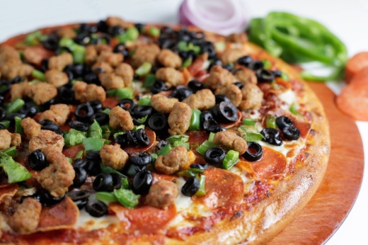 Pizza topped with meat, olives and other ingredients.