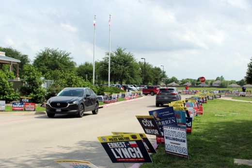 Voting signs and cars driving at Gay library