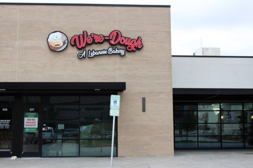 Exterior of a strip mall with We're-Dough Lebanese Bakery signage.