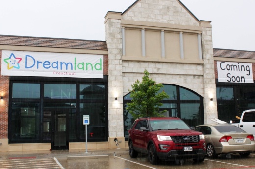 Exterior of a strip mall with Dreamland Preschool Coming Soon temporary signage.