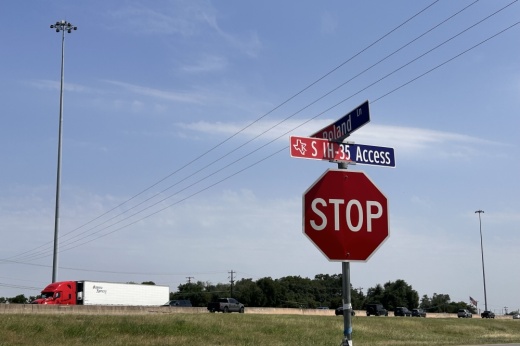 a photo of a stop sign in front of the highway