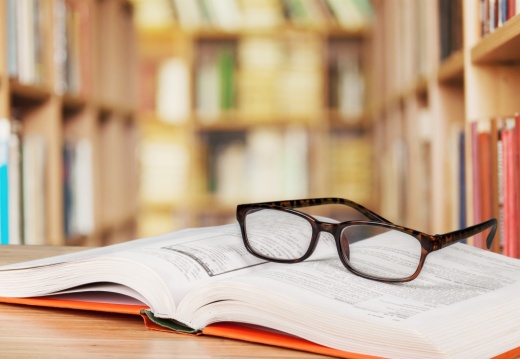 Textbook with glasses on top in a library