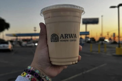 A hand holding iced coffee