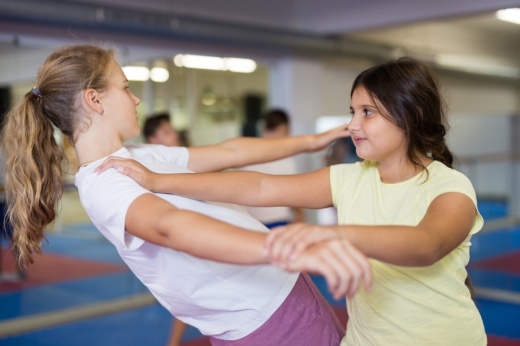 Two girls practice self-defense moves.