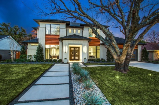 Exterior of a house at twilight with emphasis on landscaping elements.