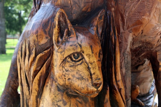 Close up of a feline sculpted in wood.