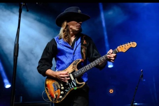 Member of Texas Flood band performing on stage.
