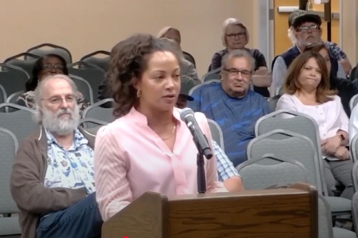 woman speaks at a city council meeting