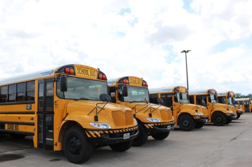 School buses parked in a line at a district transportation center