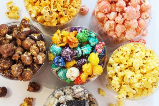 Overview of six flavors of popcorn in clean containers.