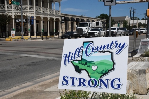 A sign reading "hill country strong" outside of a small business in Boerne.