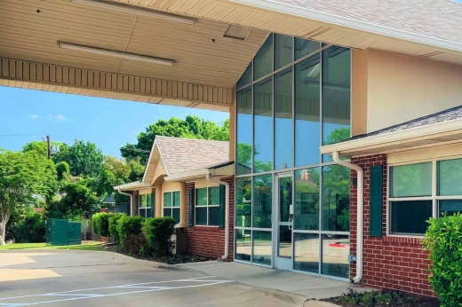 Exterior of a building featuring floor to ceiling windows and a carport.