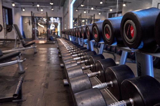 The image shows a dumb bell rack in a weight room.