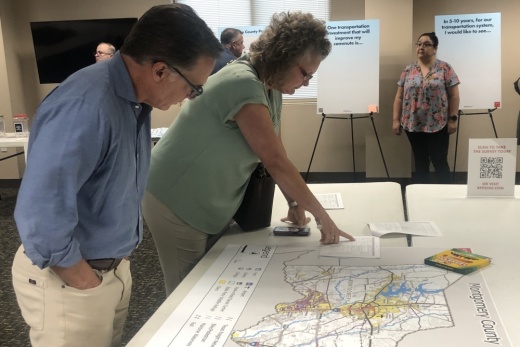 Residents such as Shannon Reid look at maps provided by H-GAC officials during the Aug. 12 meeting. (Jessica Shorten/Community Impact)