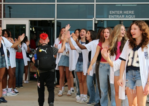 Student walking past other students to enter the school
