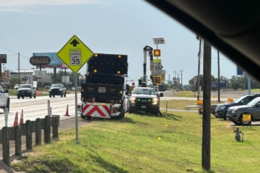 The image shows work trucks on a road.