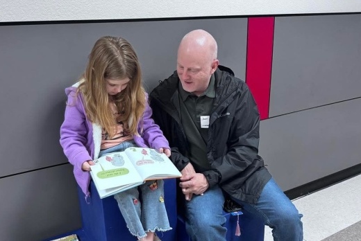 man helping girl read book