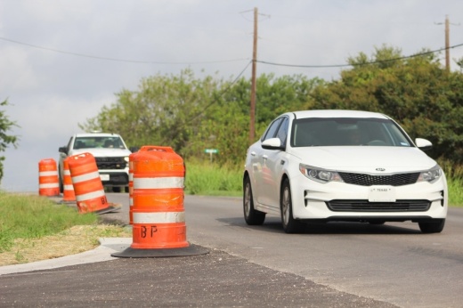 Traffic is shown on a road undergoing work in Hays County