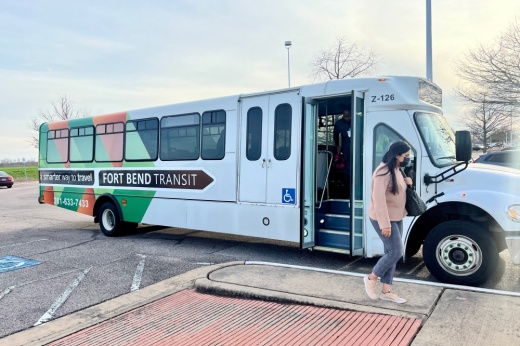 woman gets off of a bus