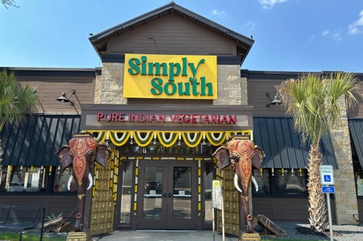 Exterior of a building featuring Simply South signage and two elephant statues flanking the entrance.