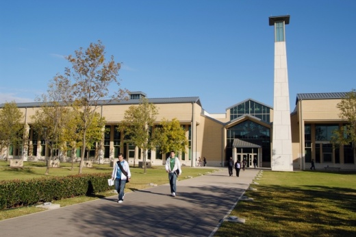 a group of students walk on a college campus
