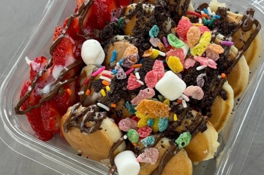 Bowl of mini pancakes with toppics such as cereal and marshmallows