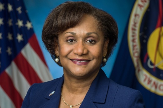 a woman takes a portrait headshot next to the American flag