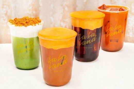 Various drinks in clear plastic cups featuring LaLa Land branding.