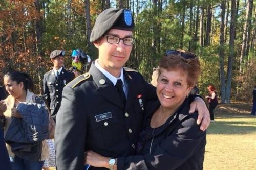 a man in a military uniform hugs a woman