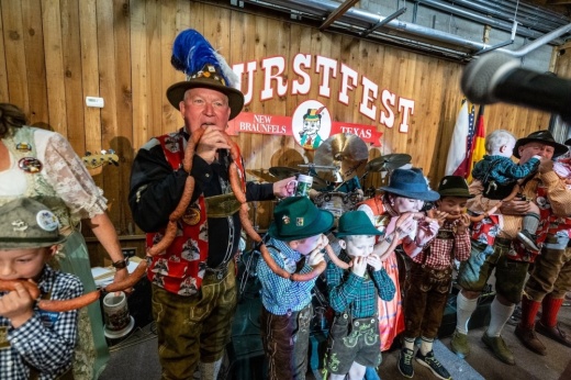 A group bites bratwurst to kick off a German festival.