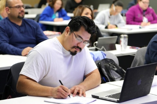 A student takes notes during a college class.
