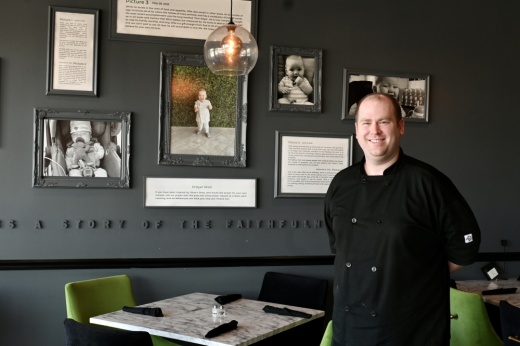 man in front of wall of photos