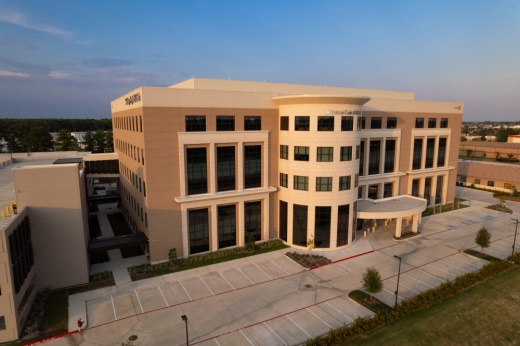 aerial view of a beige building with windows and a parking lot