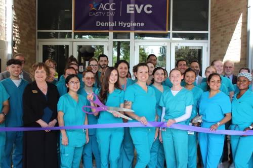 Students stand and cut a ribbon