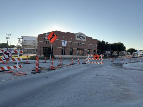 view of a main street with buildings and road work barriers in the street