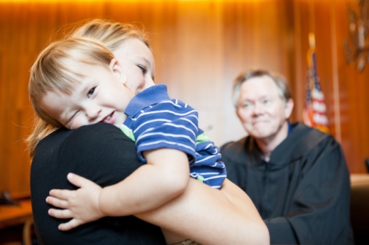 a boy hugs a woman in a courtroom