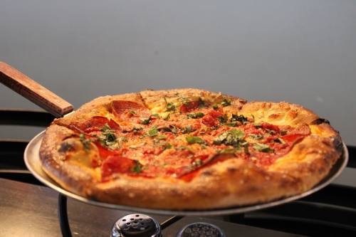 Customers can choose from a variety of 12 or 18 inch oven fired pizzas, such as this margherita topped with pepperoni and basil. (Andrew Creelman/Community Impact)