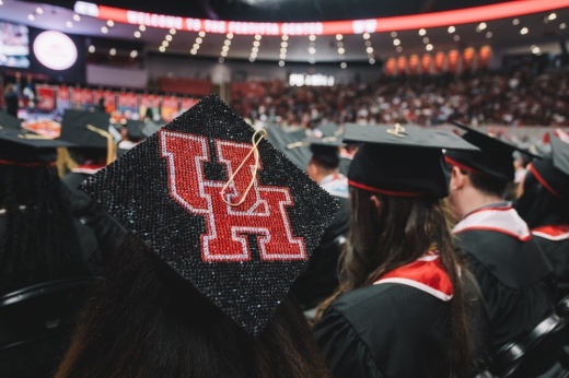 a graduate wear a black cap with the University of Houston logo on it