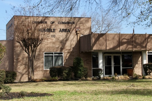 a brown building is covered by shadows of trees