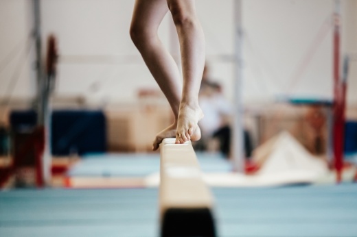 a young girl practices on a balance beam