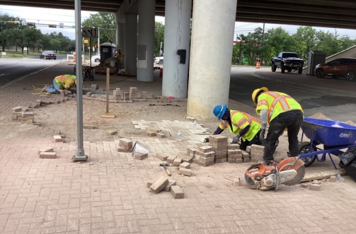 construction workers work on a sidewalk